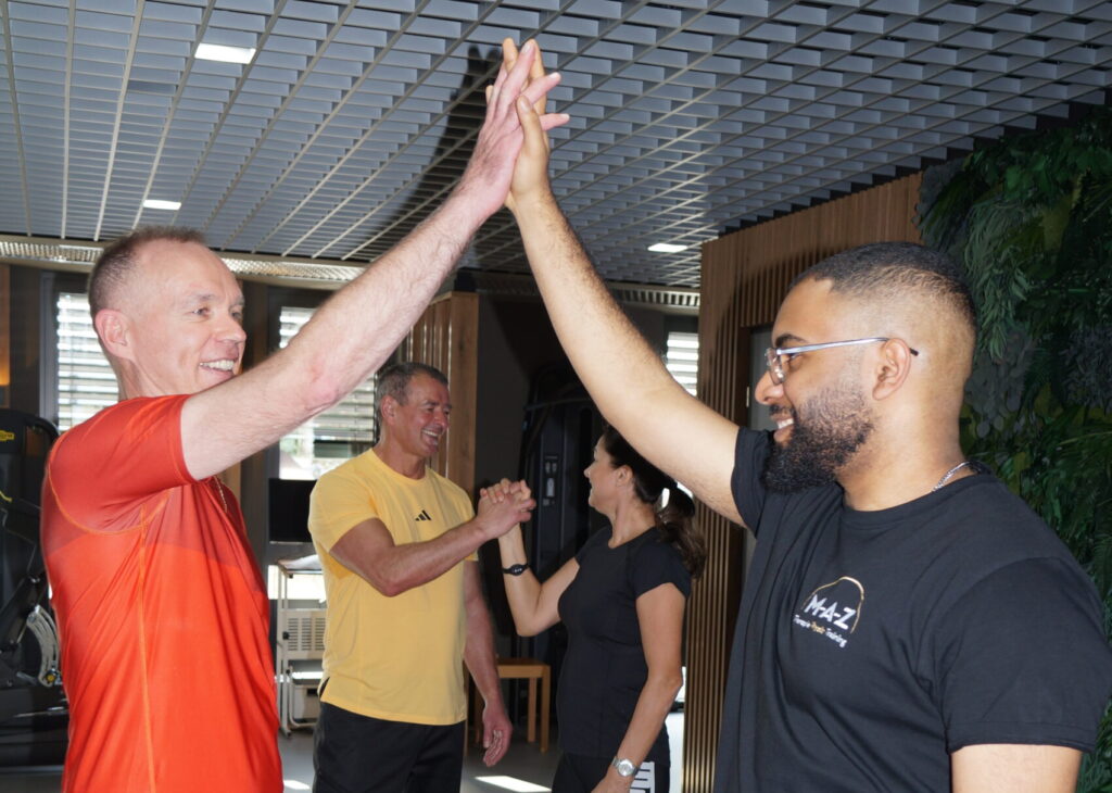 Trainer und Patient machen ein Highfive