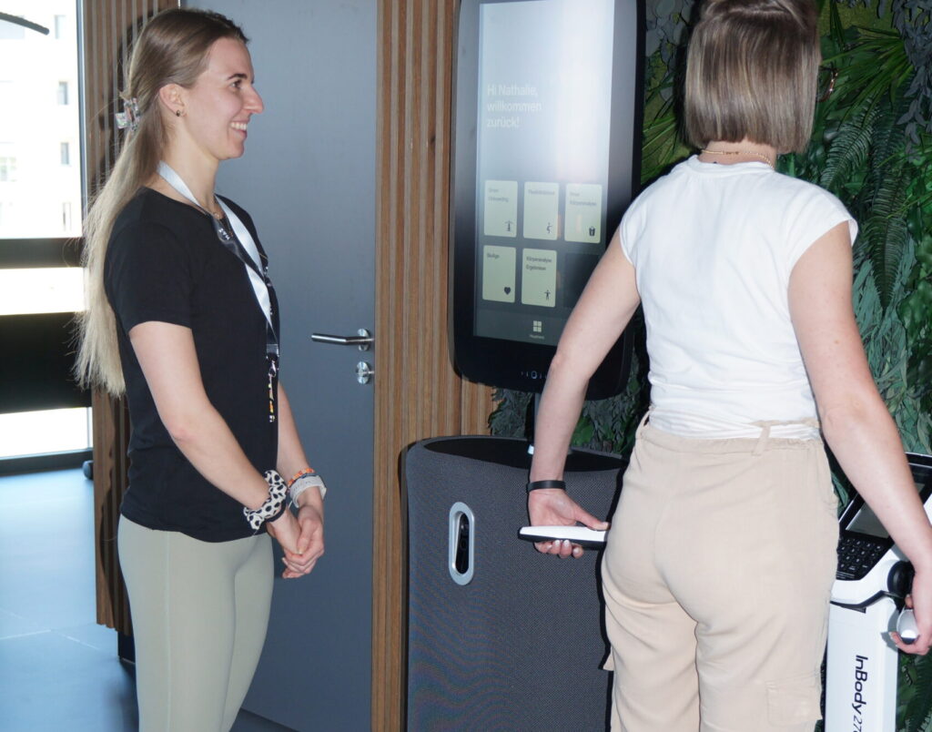 Trainerin mit Patientin bei einer Körperanalyse